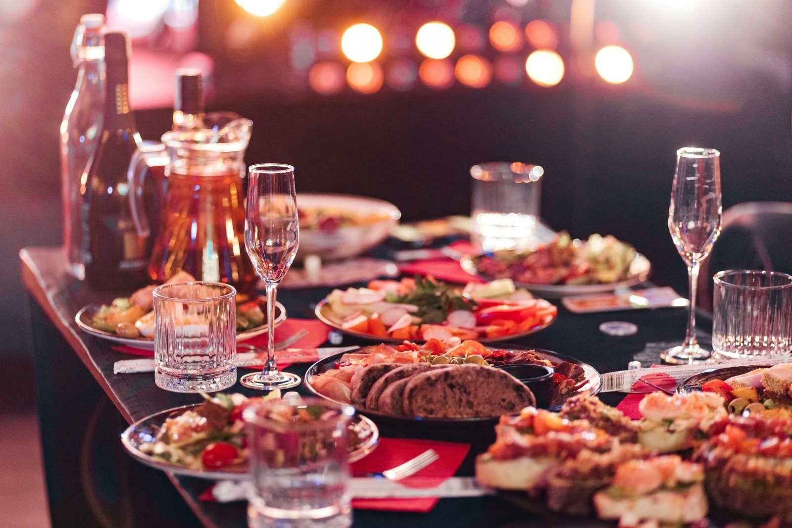 A beautifully set dinner party table with wine, appetizers, and crystal glasses, ready for a celebration.
